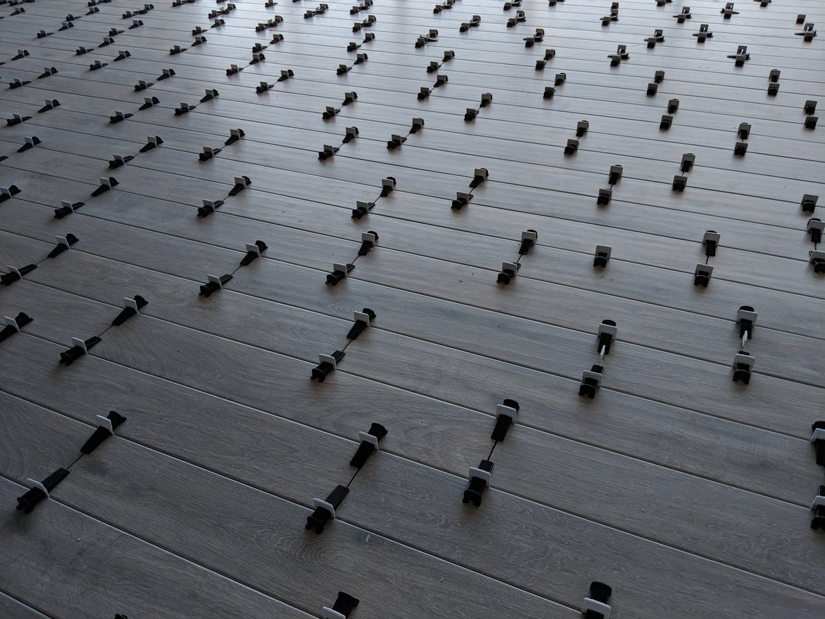 CLIP-IT tile levelling clips and wedges in use on a tiled floor